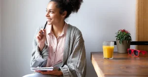 A person thinking or journaling with “Why?” on a notebook