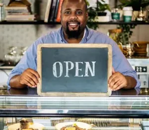 Confident small business owner smiling outside a shop or workspace